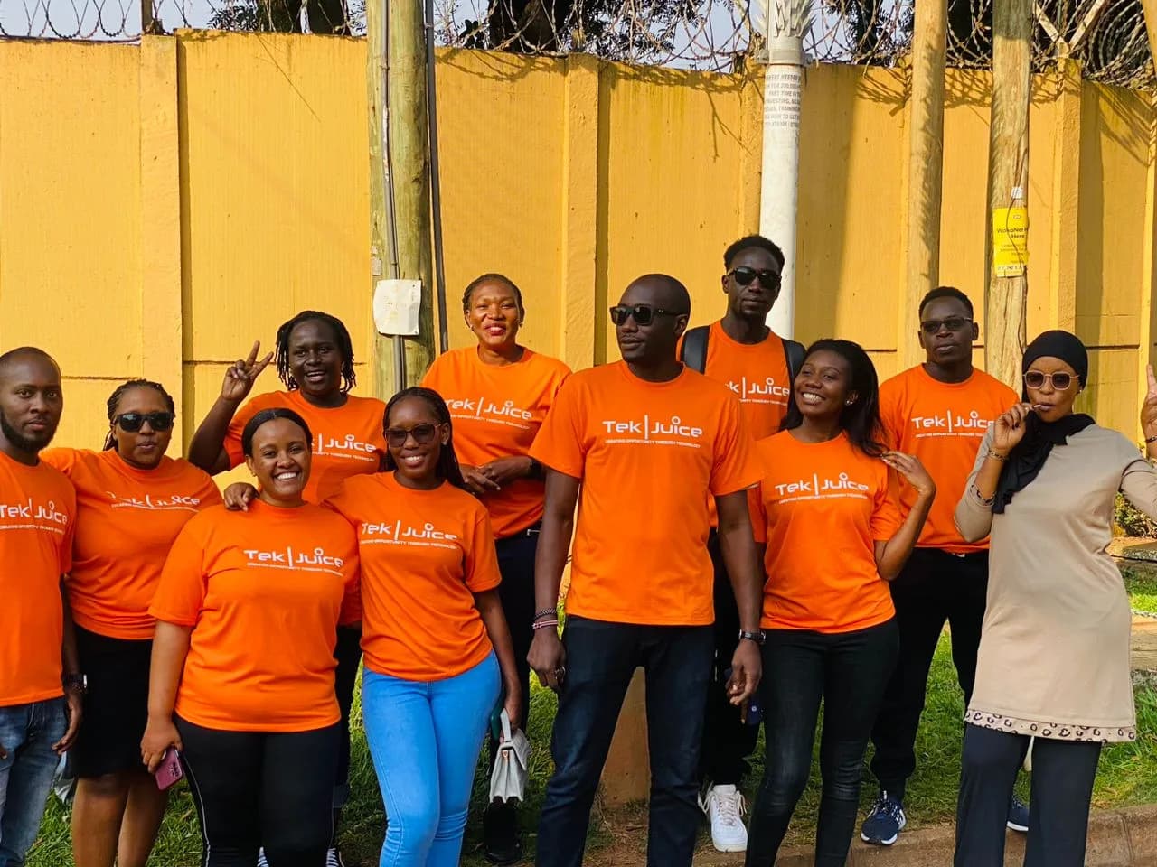 The Tek Juice team in orange, outside the studio